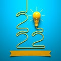 `2022` laid out of a wire and a light bulb on a blue background. Royalty Free Stock Photo