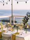 Laid table with bouquets of flowers on the balcony of the restaurant over the sea Royalty Free Stock Photo