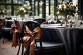 laid tablesBlack dressed tables with gold bows and white floral centerpieces set regal tone for sophisticated gala or Royalty Free Stock Photo