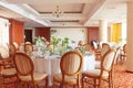 Laid wedding table with glass goblets and flowers on a colored carpet