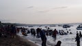 Unrecognizable young active people enjoy swimming in the shallow waters of the sea during the hot summer. Silhouettes, blurs