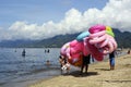 Young man sells and peddles ring lifebuoy on white sand beach