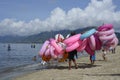 Young man sells and peddles ring lifebuoy on white sand beach