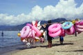 Young man sells and peddles ring lifebuoy on white sand beach