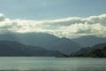 A lake on a background of green mountain valley and blue sky with white clouds Royalty Free Stock Photo