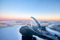 Lake Baikal is covered with ice and snow, strong cold, thick clear blue ice. Icicles hang from the rocks. Lake Baikal is a frosty Royalty Free Stock Photo