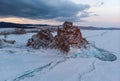 Lake Baikal. Island Olkhon. Shamanka Rock on a cloudy winter morning. Royalty Free Stock Photo