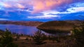 Lake Baikal. Pink, numerous cumulus clouds were lit up by the sunset in the sky. The lights of the sun. Reflections in the water. Royalty Free Stock Photo