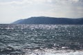 Lake Baikal. A quiet summer evening. View from the water to the west coast and the pebble shoal Royalty Free Stock Photo
