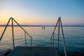 Lake Balaton at sunset with bathers and a stairs to the water