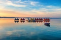 Lake Balaton at sunset with pedalos, kayaks and a boat in the foreground Royalty Free Stock Photo