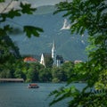 Bled lake with a church Zupnijska cerkev svetega Martina- Church of St. Martina, Bled, in a frame of leaves in summer day time Royalty Free Stock Photo