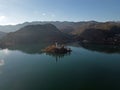 Lake Bled island with sun rays in the snowless winter aerial