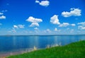 Lake, blue cloudy sky and green grass Royalty Free Stock Photo