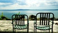 Lake Bracciano from the long lake of Trevignano Romano, with pair of metal chairs in the foreground