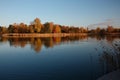 Lake with calm water mirror a forest by autumn