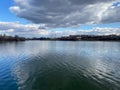 Lake with city and cloud reflections and rippled water landscape view of Royalty Free Stock Photo