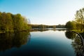 A lake in the city park early in the morning. Quiet and peaceful, in harmony, no people. Fresh green trees and grass, blue sky and Royalty Free Stock Photo