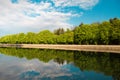 A lake in the city park early in the morning. Quiet and peaceful, in harmony, no people. Fresh green trees and grass, blue sky and Royalty Free Stock Photo