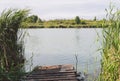 Lake on a clear summer day against the forest, with a pier in the foreground Royalty Free Stock Photo