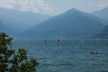 Lake Como, Italy - July 21, 2019: View of mountain lake on a sunny summer day. Windsurfers and a boat passing. District of Como