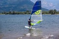 Lake Como, Italy - July 21, 2019. Water sport: windsurfer riding on a bright sunny summer day near the Colico, town in Italy. Alp Royalty Free Stock Photo