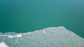 The lake is covered with green ice. The lake freezes. A top view shot with a drone.