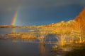 Lake covered by ice and rainbow