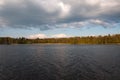 Lake with dark blue water and a green forest on a summer day