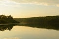 Lake with a dense forest along the banks of a summer evening Royalty Free Stock Photo