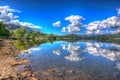 The Lake District England UK at Ullswater with mountains and blue sky on beautiful summer day with reflections in HDR Royalty Free Stock Photo
