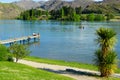 Lake Dunstan scene with young group young people sitting together on end of jetty