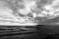 A lake at dusk, with majestic cloudscape, dark water and an island in the background Royalty Free Stock Photo