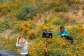 Lake Elsinore, California - March 22, 2019: Tourists clearly disrespecting signs and breaking rules, posing by a Please Stay Off