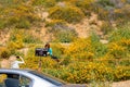 Lake Elsinore, California - March 22, 2019: Tourists clearly disrespecting signs and breaking rules, posing by a Please Stay Off