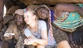 Hadza man in a cave, posing with a western woman for a picture