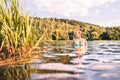 Lake in Finland. Happy smiling woman swimming in water summer. Finnish nature at sunset. Pretty girl in swimsuit or bikini.