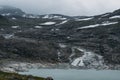 lake on foot of rock with snow on surface, Norway, Hardangervidda Royalty Free Stock Photo