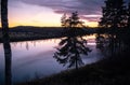 Lake in the forest reflecting the beautiful colors of the cloudy sunset sky Royalty Free Stock Photo