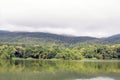 Lake with forest reflection wave and The mountain is covered with fog. Royalty Free Stock Photo