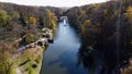 Lake, fountain, trees, large stones and lot of people walking sunny autumn day