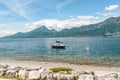 Moored sailboat with white and orange buoys, at the stern, on lake Garda shoreline Royalty Free Stock Photo