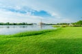Lake and green grass field at the park. Watercycle in lake near pavilion. Lawn and garden in the park on summer. Green tree and Royalty Free Stock Photo