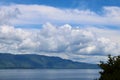 Lake landscape blue water, hill view from the top. Clear sky with green wood. Large panorama while travelling Royalty Free Stock Photo