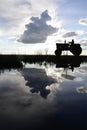 Lake landscape with the silhouette of a tractor driver Royalty Free Stock Photo