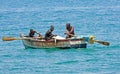 Three men in a small rowing boat