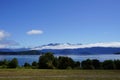 Lake Manapouri - bush , meadow , coastline, mountains, clouds, blue sky Royalty Free Stock Photo