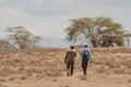 Armed guard and a man tourist on a walking safari on Crescent Island look for wildlife