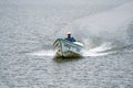 Man captains a speedboat on the lake, creating a wake behind him