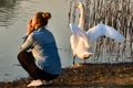 On the lake near the girl the swan gracefully opened its wings